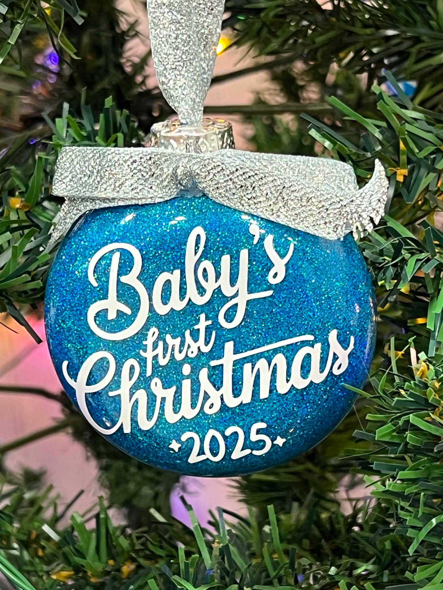 Blue glitter ornament reading Baby's first Christmas 2025